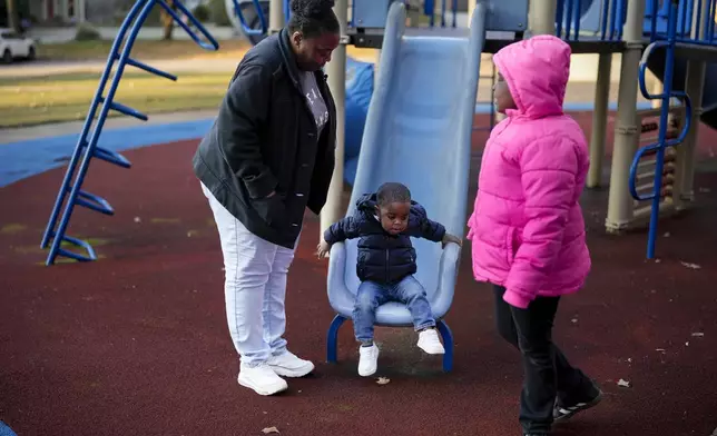 Anika Chillis spends time with her children, Makhi 2, and Myla 9, at a playground Monday, Dec. 2, 2024, in Memphis, Tenn. (AP Photo/George Walker IV)