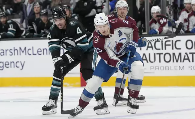 Colorado Avalanche center Nathan MacKinnon (29) skates toward the puck against San Jose Sharks defenseman Cody Ceci (4) during the first period of an NHL hockey game in San Jose, Calif., Thursday, Dec. 19, 2024. (AP Photo/Jeff Chiu)