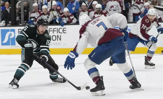 San Jose Sharks right wing Nikolai Kovalenko (15) skates with the puck against Colorado Avalanche defenseman Devon Toews (7) during the first period of an NHL hockey game in San Jose, Calif., Thursday, Dec. 19, 2024. (AP Photo/Jeff Chiu)