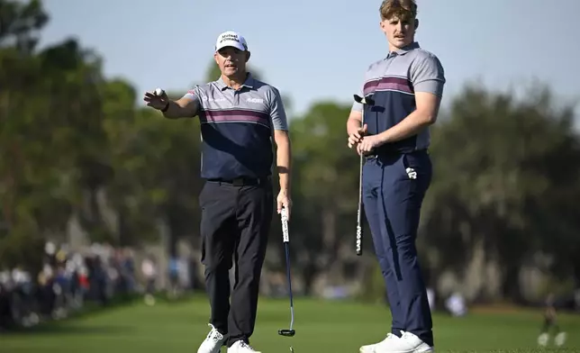 Padraig Harrington, left, and his son Paddy Harrington line up their putt on the 18th green hole during the first round of the PNC Championship golf tournament, Saturday, Dec. 21, 2024, in Orlando, Fla. (AP Photo/Phelan M. Ebenhack)