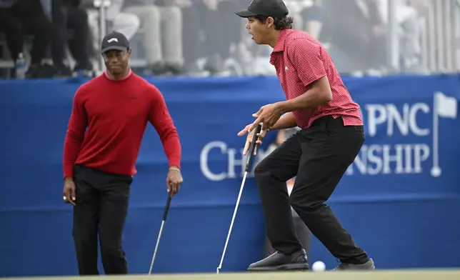 Tiger Woods, left, and Charlie Woods react after missing a putt during a playoff hole on the 18th green to win the PNC Championship golf tournament, Sunday, Dec. 22, 2024, in Orlando, Fla. (AP Photo/Phelan M. Ebenhack)