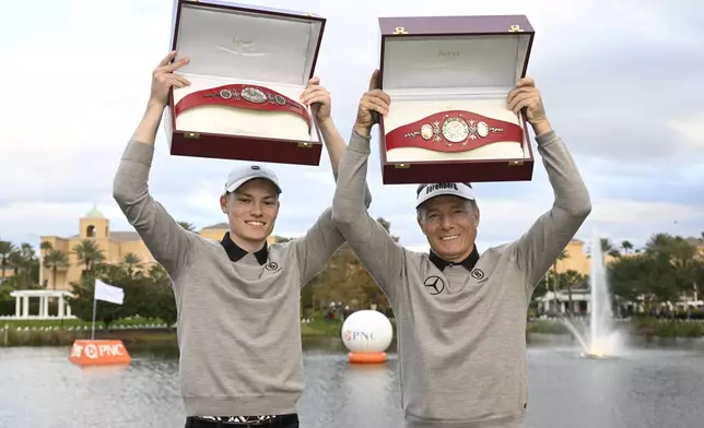 Bernhard Langer, right, and his son Jason Langer hold the championship belts after winning the PNC Championship golf tournament, Sunday, Dec. 22, 2024, in Orlando, Fla. (AP Photo/Phelan M. Ebenhack)