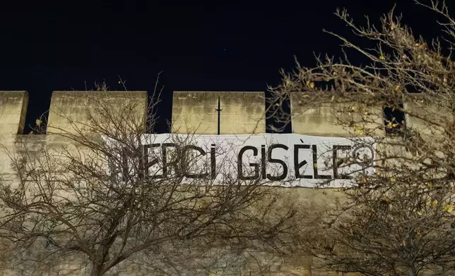 Members of the feminist collective "Les Amazones Avignon" hang a banner reading "Thank you Gisele" during their action of collage of messages of support near the courthouse where the Mazan rape trial is taking place in Avignon, France, Wednesday, Dec. 18, 2024. (AP Photo/Lewis Joly)