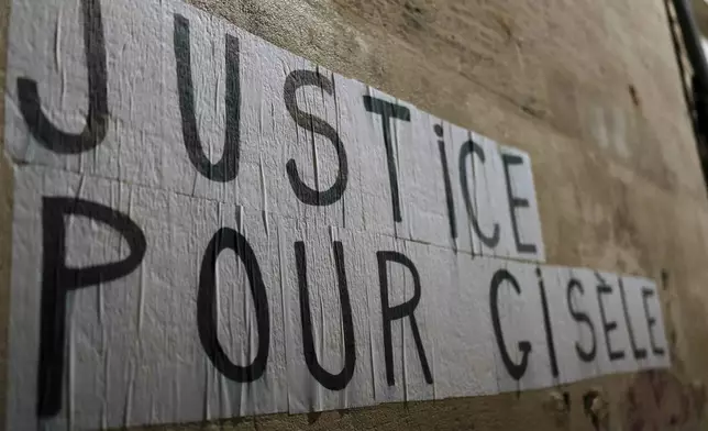 Members of the feminist collective "Les Amazones Avignon" stick a message of support for Gisele Pelicot reading "Justice for Gisele" in the streets around the courthouse where the Mazan rape trial is taking place in Avignon, France, Wednesday, Dec. 18, 2024. (AP Photo/Lewis Joly)