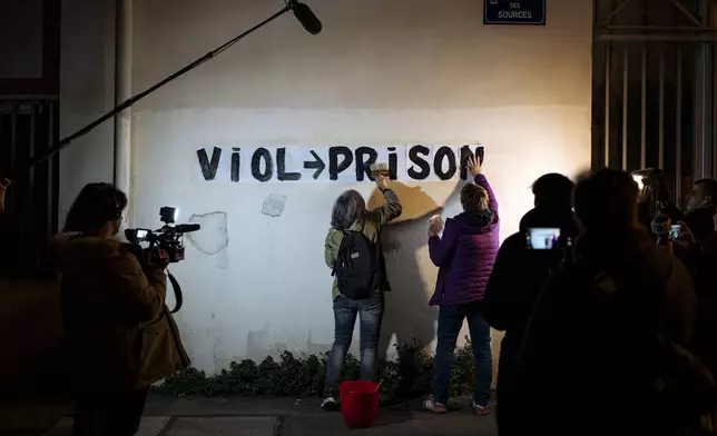 Members of the feminist collective "Les Amazones Avignon" attach a message of support for Gisele Pelicot reading "rape = jail" near the courthouse where the Mazan rape trial is taking place in Avignon, France, Wednesday, Dec. 18, 2024. (AP Photo/Lewis Joly)