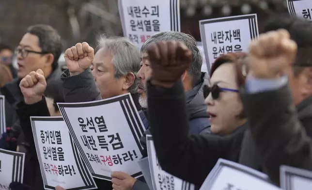 Members of civic groups shout slogans during a news conference demanding the arrest of President Yoon Suk Yeol near the presidential residence in Seoul, South Korea, Tuesday, Dec. 17, 2024. The letters read "Immediately arrest Yoon Suk Yeol." (AP Photo/Lee Jin-man)