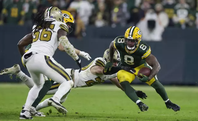 Green Bay Packers running back Josh Jacobs (8) carries against New Orleans Saints linebacker Pete Werner during the second half of an NFL football game, Monday, Dec. 23, 2024, in Green Bay, Wis. (AP Photo/Matt Ludtke)