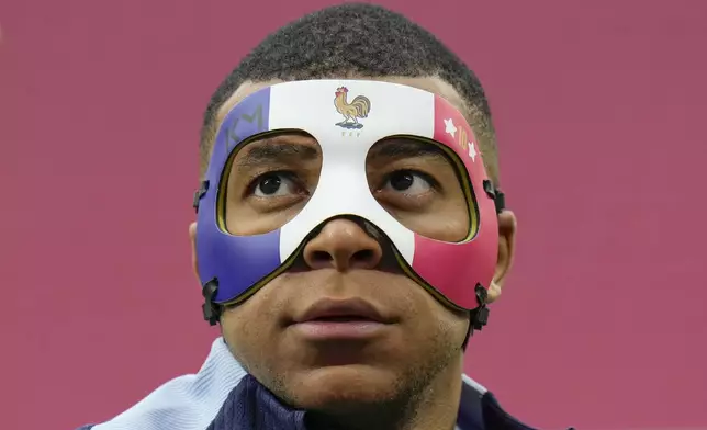 FILE - France's Kylian Mbappe looks up as he wears a face mask during a team training session in Leipzig, Germany, Thursday, June 20, 2024. (AP Photo/Hassan Ammar, file)