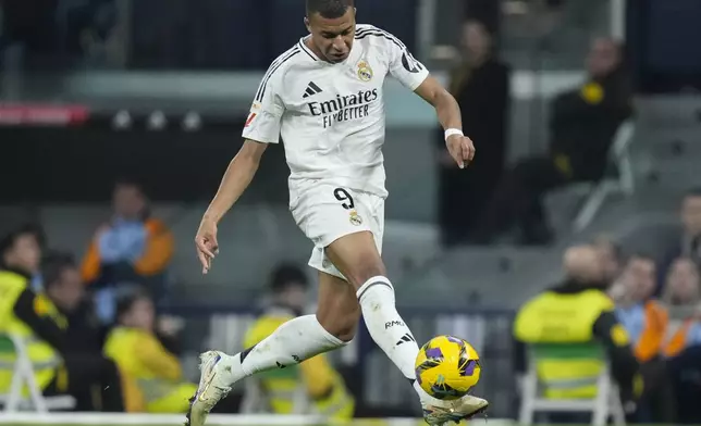 Real Madrid's Kylian Mbappe takes control of the ball during the Spanish La Liga soccer match between Real Madrid and Getafe at the Santiago Bernabeu Stadium in Madrid, Spain, Sunday, Dec. 1, 2024. (AP Photo/Bernat Armangue)