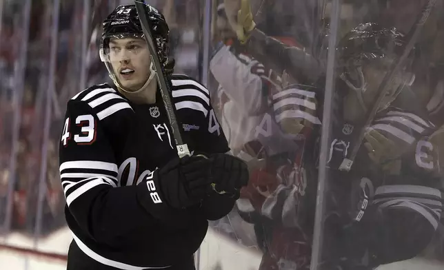 New Jersey Devils defenseman Luke Hughes reacts after scoring a goal in the second period of an NHL hockey game against the Carolina Hurricanes Friday, Dec. 27, 2024, in Newark, N.J. (AP Photo/Adam Hunger)