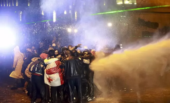 Police use a water cannon on protesters during a rally against the government's decision to suspend negotiations on joining the European Union for four years outside the parliament in Tbilisi, Georgia, on Sunday, Dec. 1, 2024. (AP Photo/Zurab Tsertsvadze)