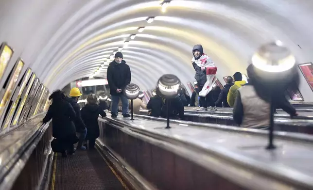 Demonstrators go down an escalator to hide from the police in a subway station during a rally against the government's decision to suspend negotiations on joining the European Union for four years in Tbilisi, Georgia, Monday, Dec. 2, 2024. (AP Photo/Zurab Tsertsvadze)