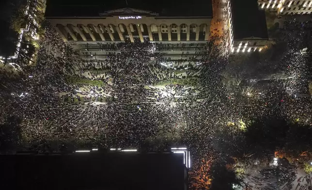 Demonstrators rally outside the parliament's building, top, to protest the government's decision to suspend negotiations on joining the European Union for four years in Tbilisi, Georgia, on Friday, Nov. 29, 2024. (AP Photo/Zurab Tsertsvadze)