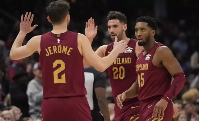 Cleveland Cavaliers guard Ty Jerome (2), forward Georges Niang (20) and guard Donovan Mitchell (45) celebrate in the first half of an NBA basketball game against the Boston Celtics, Sunday, Dec. 1, 2024, in Cleveland. (AP Photo/Sue Ogrocki)