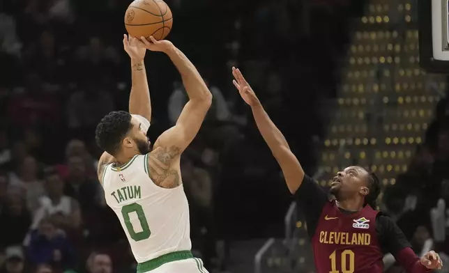 Boston Celtics forward Jayson Tatum (0) shoots over Cleveland Cavaliers guard Darius Garland (10) in the first half of an NBA basketball game, Sunday, Dec. 1, 2024, in Cleveland. (AP Photo/Sue Ogrocki)