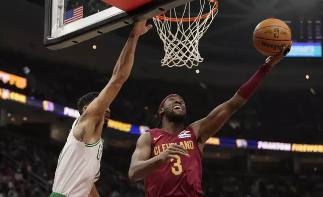 Cleveland Cavaliers guard Caris LeVert (3) shoots in front of Boston Celtics forward Jayson Tatum, left, in the first half of an NBA basketball game, Sunday, Dec. 1, 2024, in Cleveland. (AP Photo/Sue Ogrocki)