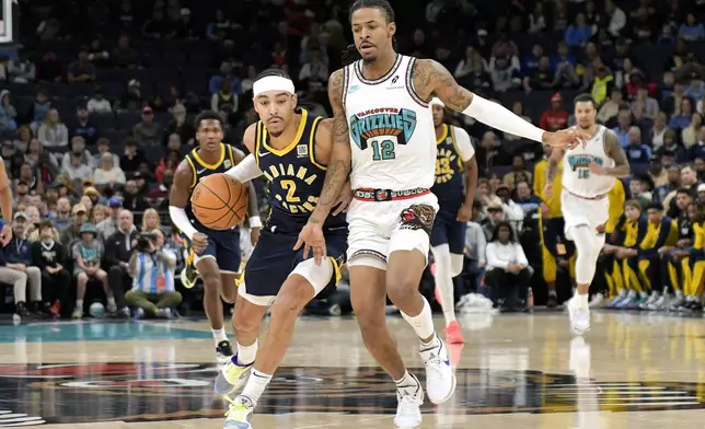 Indiana Pacers guard Andrew Nembhard (2) handles the ball against Memphis Grizzlies guard Ja Morant (12) in the first half of an NBA basketball game Sunday, Dec. 1, 2024, in Memphis, Tenn. (AP Photo/Brandon Dill)