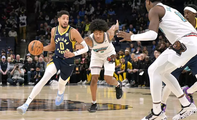 Indiana Pacers guard Tyrese Haliburton, left, handles the ball against Memphis Grizzlies forward Jaylen Wells, center, in the first half of an NBA basketball game Sunday, Dec. 1, 2024, in Memphis, Tenn. (AP Photo/Brandon Dill)