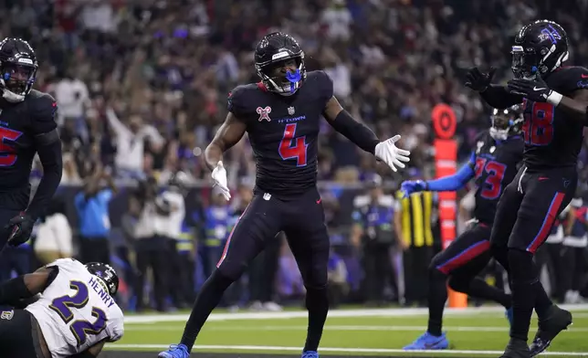 Houston Texans cornerback Kamari Lassiter (4) celebrates after tackling Baltimore Ravens running back Derrick Henry (22) for a safety during the first half of an NFL football game, Wednesday, Dec. 25, 2024, in Houston. (AP Photo/Eric Christian Smith)