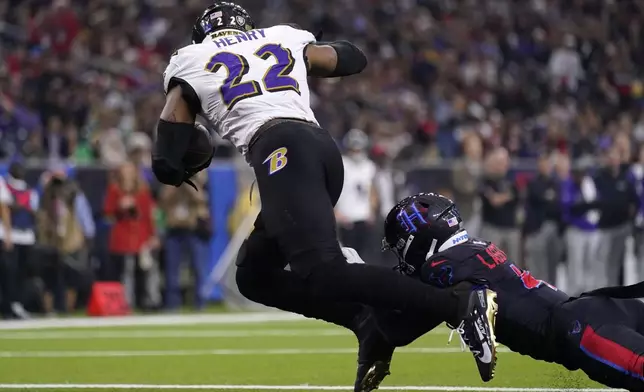 Baltimore Ravens running back Derrick Henry (22) is tackled by Houston Texans cornerback Kamari Lassiter, right, for a safety during the first half of an NFL football game, Wednesday, Dec. 25, 2024, in Houston. (AP Photo/Eric Christian Smith)