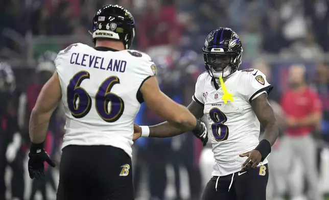 Baltimore Ravens quarterback Lamar Jackson (8) celebrates with teammate Ben Cleveland (66) after throwing a touchdown pass during the second half of an NFL football game against the Houston Texans, Wednesday, Dec. 25, 2024, in Houston. (AP Photo/David J. Phillip)