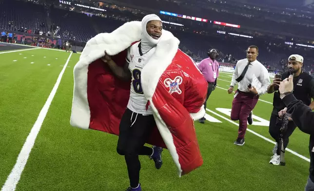 Baltimore Ravens quarterback Lamar Jackson (8) runs off the field after an NFL football game against the Houston Texans, Wednesday, Dec. 25, 2024, in Houston. (AP Photo/David J. Phillip)