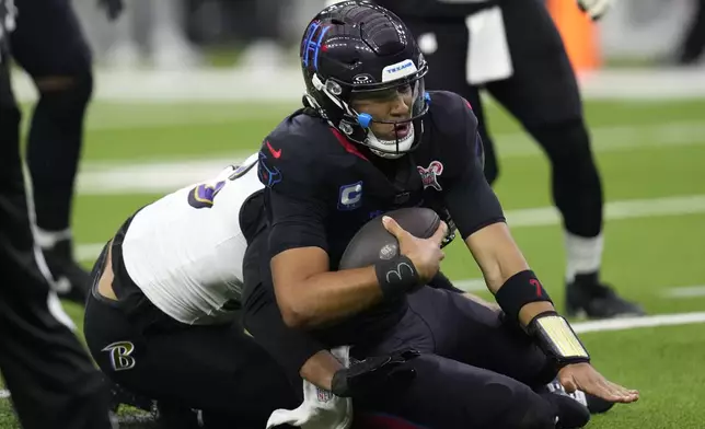 Houston Texans quarterback C.J. Stroud is sacked by Baltimore Ravens linebacker Kyle Van Noy, left, during the first half of an NFL football game, Wednesday, Dec. 25, 2024, in Houston. (AP Photo/David J. Phillip)