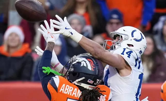 Denver Broncos' Kris Abrams-Draine breaks iup a pass intended for Indianapolis Colts' Alec Pierce during the first half of an NFL football game Sunday, Dec. 15, 2024, in Denver. (AP Photo/Jack Dempsey)