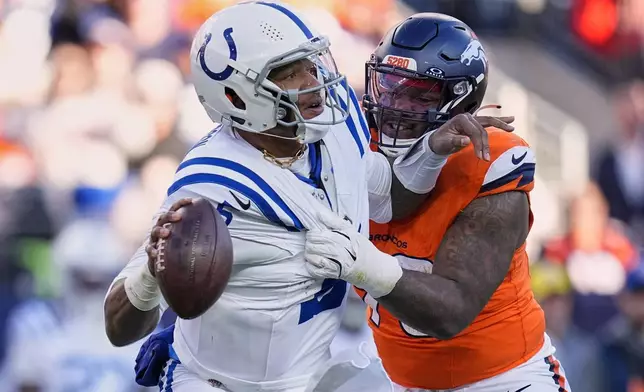 Indianapolis Colts' Anthony Richardson gets away from Denver Broncos' John Franklin-Myers during the first half of an NFL football game Sunday, Dec. 15, 2024, in Denver. (AP Photo/Jack Dempsey)