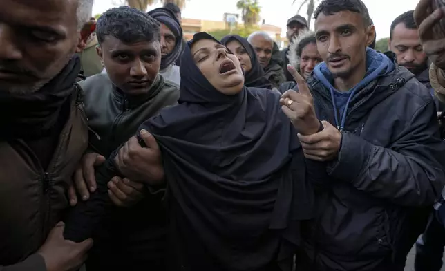 A woman reacts during the funeral of five Palestinian journalists who were killed by an Israeli airstrike in Gaza City at the Al-Aqsa Hospital in Deir al-Balah, Thursday, Dec. 26, 2024. (AP Photo/Abdel Kareem Hana)