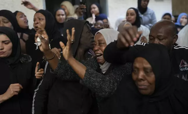 Mourners cry while they take the last look at the body of a relative, one of eight Palestinians killed, during their funeral following the withdrawal of the Israeli army, in the West Bank city of Tulkarem, Thursday, Dec. 26, 2024. (AP Photo/Matias Delacroix)