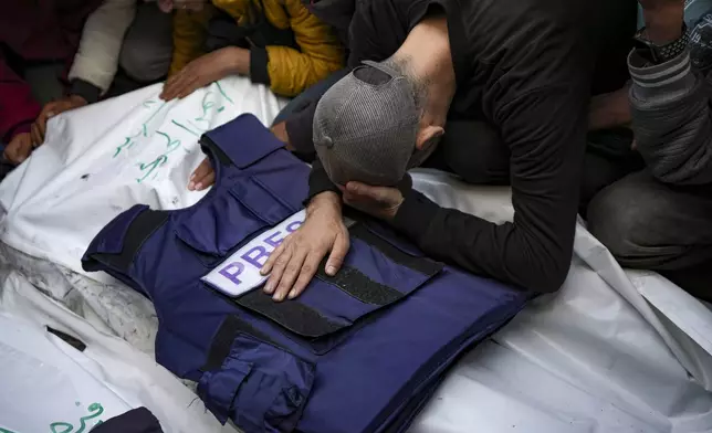 A relative mourns over the body of one of the five Palestinian journalists who were killed by an Israeli airstrike in Gaza City at the Al-Aqsa Hospital in Deir al-Balah, Thursday, Dec. 26, 2024. (AP Photo/Abdel Kareem Hana)