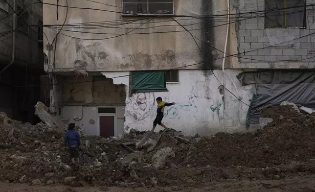 A boy walks along of a damaged street after the latest Israeli military operation, in the West Bank city of Tulkarem, Thursday, Dec. 26, 2024. (AP Photo/Matias Delacroix)