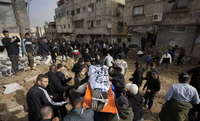 Mourners carry the bodies of eight killed Palestinians, some are wrapped with the Islamic Jihad flag, during their funeral following the withdrawal of the Israeli army, in the West Bank city of Tulkarem, Thursday, Dec. 26, 2024. (AP Photo/Matias Delacroix)