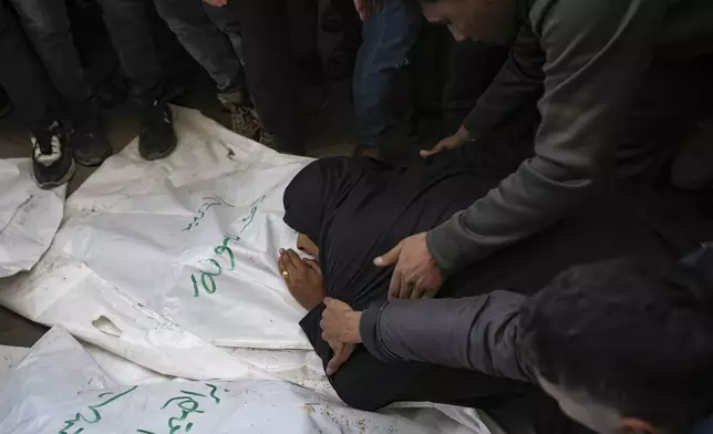 A relative mourns over the body of one of the five Palestinian journalists who were killed by an Israeli airstrike in Gaza City at the Al-Aqsa Hospital in Deir al-Balah, Thursday, Dec. 26, 2024. (AP Photo/Abdel Kareem Hana)