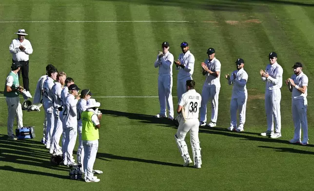 England players form a guard of honor as New Zealand batsman Tim Southee walks out to bat in his final test match during play on day one of the third cricket test between England and New Zealand in Hamilton, New Zealand, Saturday, Dec. 14, 2024. (Andrew Cornaga/Photosport via AP)