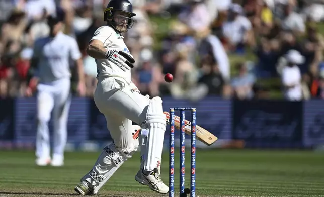 New Zealand batsman Kane Williamson attempts to kick the ball away from his stumps during play on day one of the third cricket test between England and New Zealand in Hamilton, New Zealand, Saturday, Dec. 14, 2024. (Andrew Cornaga/Photosport via AP)