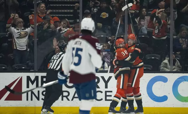 Anaheim Ducks center Leo Carlsson (91) celebrates after his goal with center Jansen Harkins (38) during the second period of an NHL hockey game against the Colorado Avalanche, Friday, Dec. 20, 2024, in Anaheim, Calif. (AP Photo/Kyusung Gong)