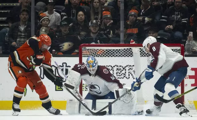 Colorado Avalanche defenseman Cale Makar (8) and goaltender Scott Wedgewood (41) stop a shot by Anaheim Ducks left wing Alex Killorn, left, during the second period of an NHL hockey game, Friday, Dec. 20, 2024, in Anaheim, Calif. (AP Photo/Kyusung Gong)