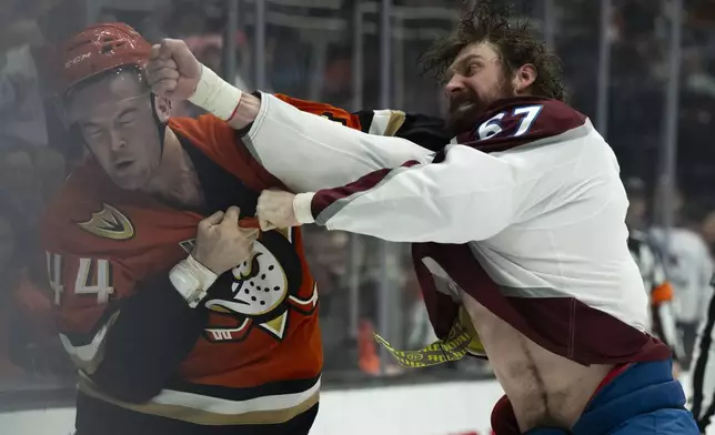 Colorado Avalanche defenseman Keaton Middleton (67) and Anaheim Ducks left wing Ross Johnston (44) fight during the first period of an NHL hockey game, Friday, Dec. 20, 2024, in Anaheim, Calif. (AP Photo/Kyusung Gong)