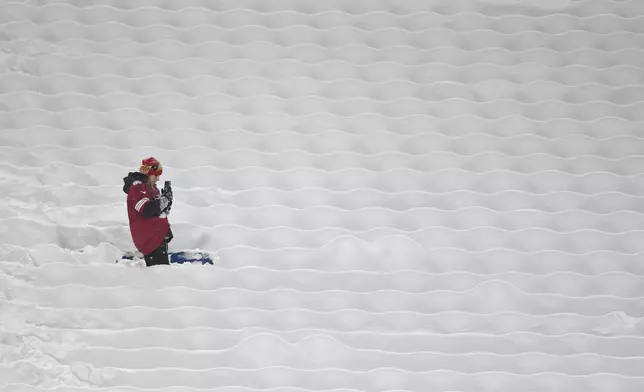 A San Francisco 49ers fan stands between snow covered seats before an NFL football game between the Buffalo Bills and the 49ers in Orchard Park, N.Y., Sunday, Dec. 1, 2024. (AP Photo/Adrian Kraus)