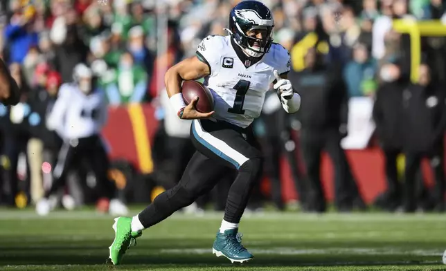 Philadelphia Eagles quarterback Jalen Hurts (1) runs with the ball during the first half of an NFL football game against the Washington Commanders, Sunday, Dec. 22, 2024, in Landover, Md. (AP Photo/Nick Wass)