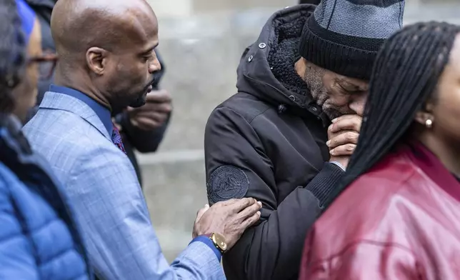 Attorney Donte Mills, left, comforts an emotional Andre Zachary, father of Jordan Neely, outside the criminal court, Monday, Dec. 9, 2024, in New York. (AP Photo/Stefan Jeremiah)