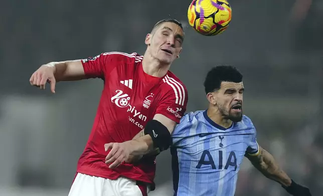 Nottingham Forest's Nikola Milenkovic and Tottenham Hotspur's Dominic Solanke, right, challenge for the ball during the English Premier League soccer match between Nottingham Forest and Tottenham Hotspur at the City Ground stadium in Nottingham, England, Thursday, Dec. 26, 2024. (Mike Egerton/PA via AP)