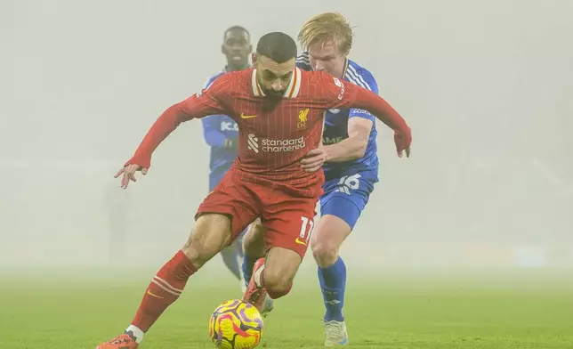 Liverpool's Mohamed Salah, front, controls a ball chased by Leicester's Victor Kristiansen during a English Premier League soccer match at the Anfield stadium in Liverpool, Thursday, Dec. 26, 2024. (AP Photo/Ian Hodgson)