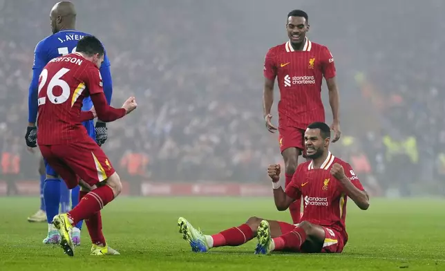 Liverpool's Cody Gakpo, right, celebrates with teammates after scoring his side's first goal against Leicester City during the English Premier League soccer match at the Anfield stadium in Liverpool, Thursday, Dec. 26, 2024. (Peter Byrne/PA via AP)