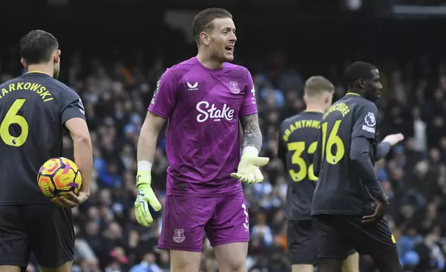 Everton's goalkeeper Jordan Pickford, center, reacts after saving a penalty kick by Manchester City's Erling Haaland during the English Premier League soccer match between Manchester City and Everton at the Etihad stadium in Manchester, Thursday, Dec. 26, 2024. (AP Photo/Rui Vieira)