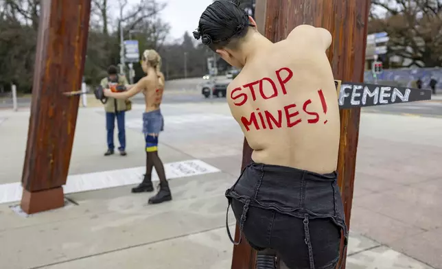 Activists of the feminist group Femen protest to support Ukraine and to demand Russia's expulsion from the UN, under the 'Broken Chair' Monument on Place des Nations in front of the European headquarters of the United Nations (UN) in Geneva, Switzerland, Friday, Dec. 13, 2024. (Salvatore Di Nolfi/Keystone via AP)