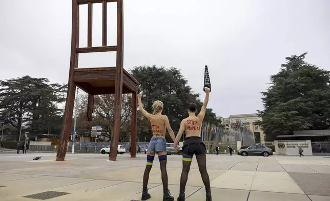 Activists of the feminist group Femen protest to support Ukraine and to demand Russia's expulsion from the UN, under the 'Broken Chair' Monument on Place des Nations in front of the European headquarters of the United Nations (UN) in Geneva, Switzerland, Friday, Dec. 13, 2024. (Salvatore Di Nolfi/Keystone via AP)