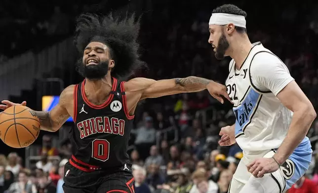 Chicago Bulls guard Coby White (0) moves against Atlanta Hawks forward Larry Nance Jr. (22) during the first half of an NBA basketball game, Thursday, Dec. 26, 2024, in Atlanta. (AP Photo/Mike Stewart)